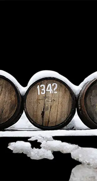 Schneebedeckte Holzfässer mit Kennzeichnung während der Reifung des Grappas